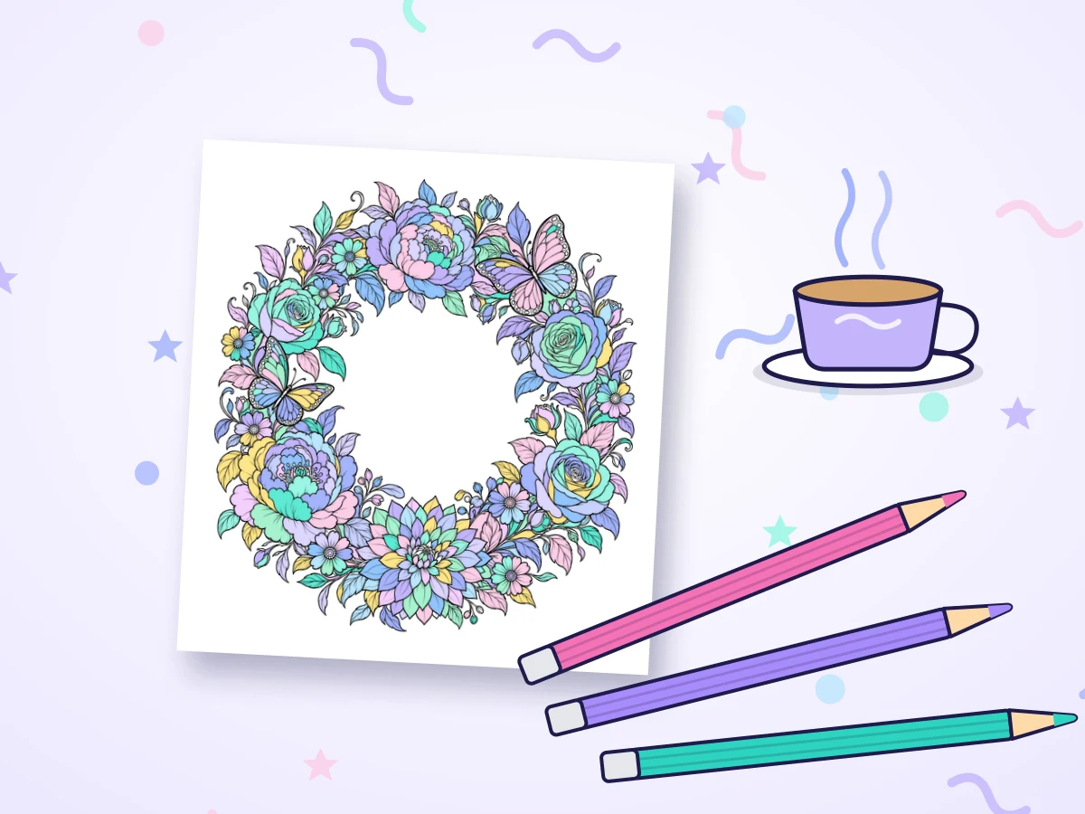 A softly colored flower wreath next to colored pencils and a cup of tea
